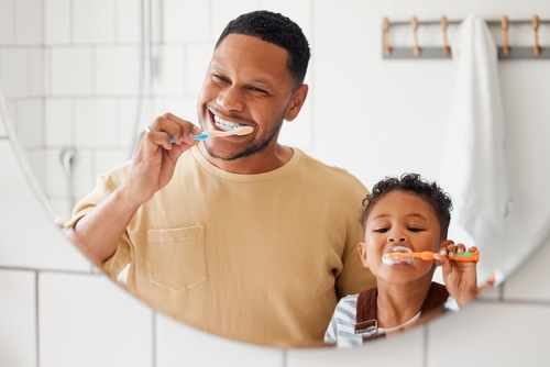 father and child brushing their teeth